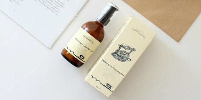 DRESSINGTABLE Brightening Iron Tone-Up Lotion bottle and packaging on a minimalist surface.