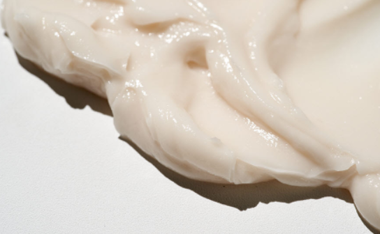 Creamy texture of IN YOUR HEART Calming Care Cream on a white surface, showcasing its soothing formula.