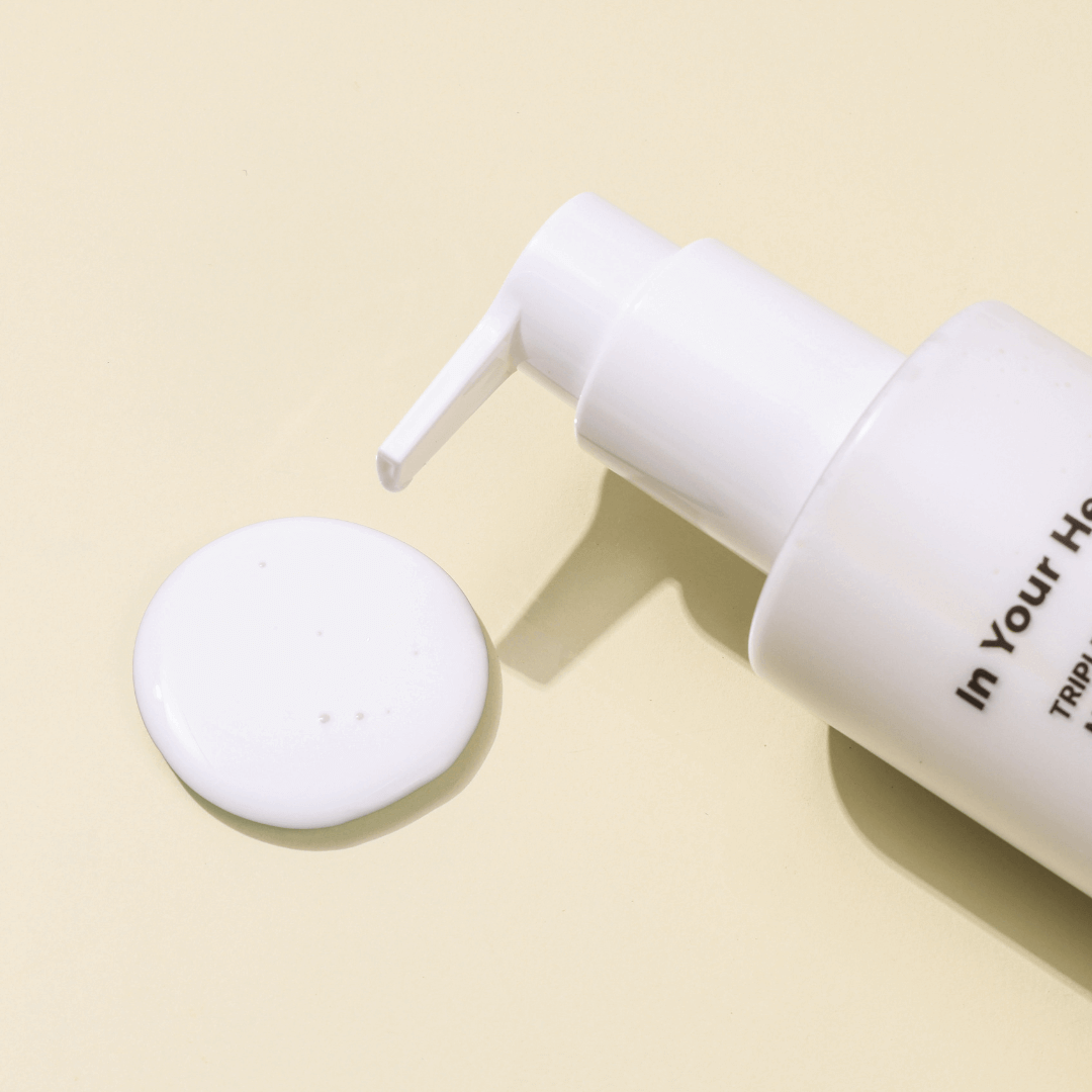 IN YOUR HEART Triple Essence Milk Cleanser bottle with milky essence on a light background, showcasing its unique texture.