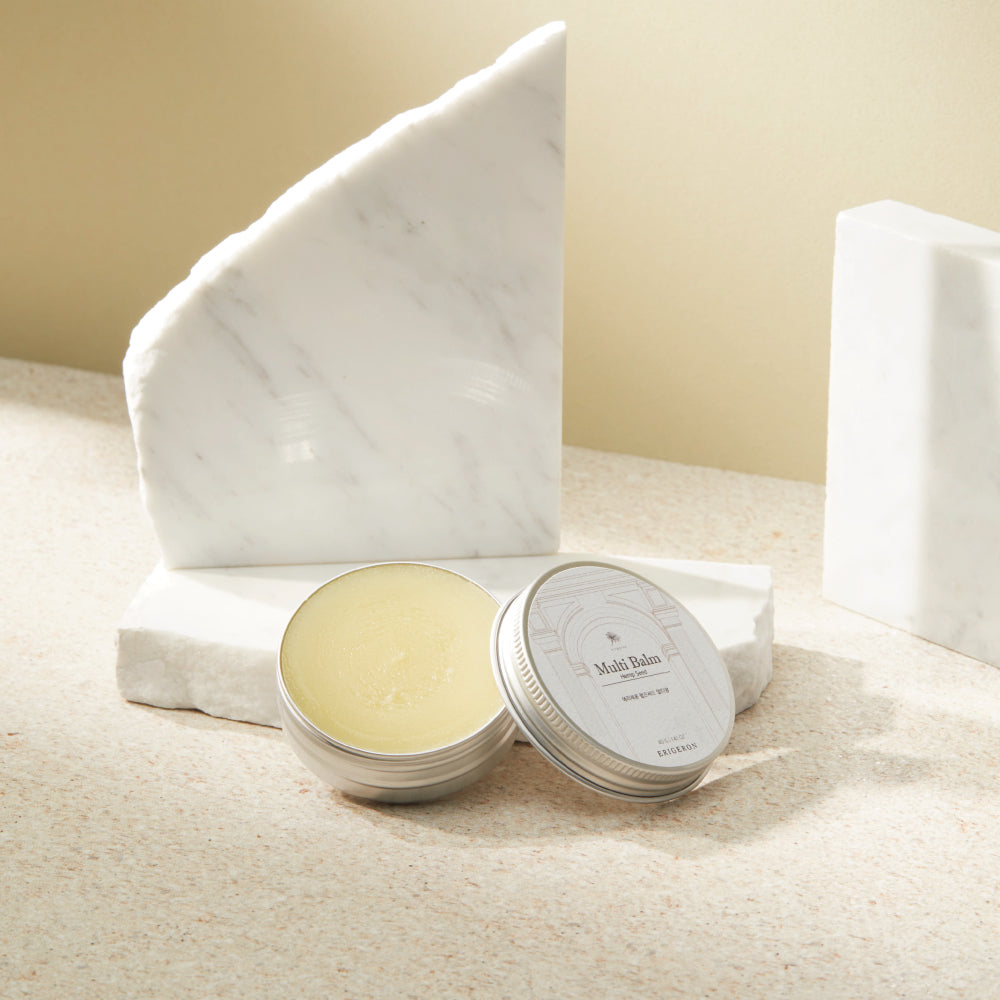 Erigeron Hemp Seed Multi Balm in silver tin can displayed next to marble pieces