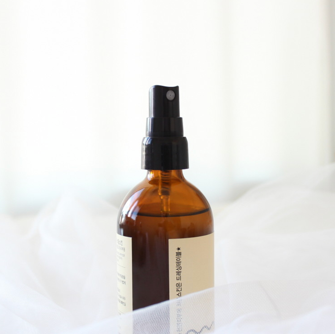 DRESSINGTABLE Brightening Iron Steam Skin in a brown glass spray bottle against a soft white background.