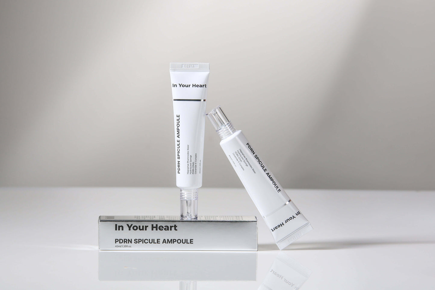 IN YOUR HEART PDRN Spicule Ampoule & Calming Care Cream Duo displayed on a reflective surface.
