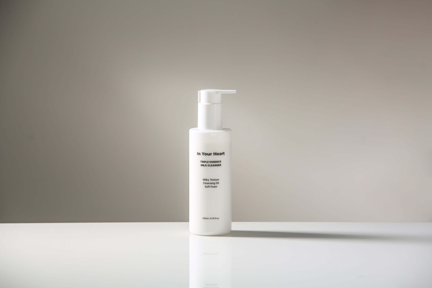 IN YOUR HEART Triple Essence Milk Cleanser bottle on a clean surface with a simple background.