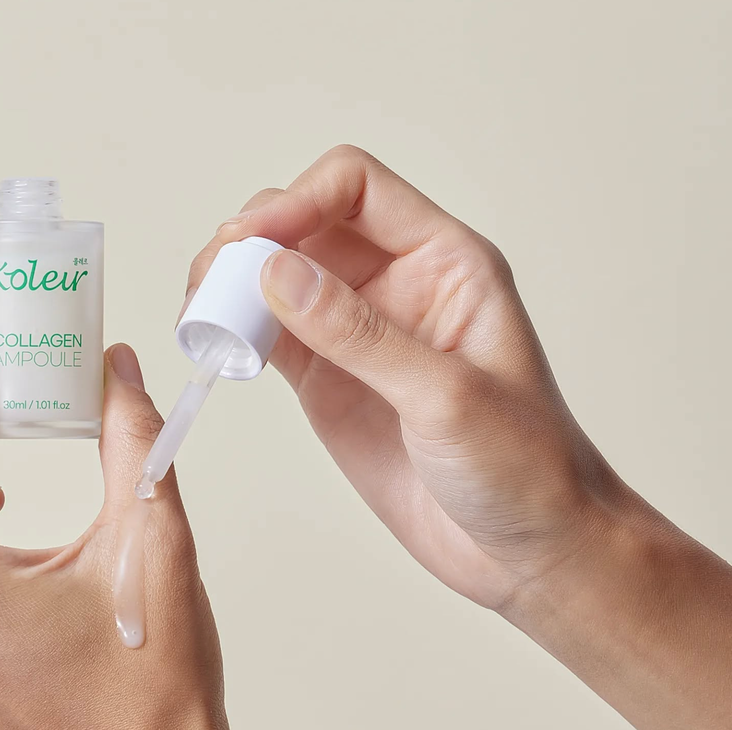 Hand holding a dropper dispensing KOLEUR Collagen Ampoule for skincare.