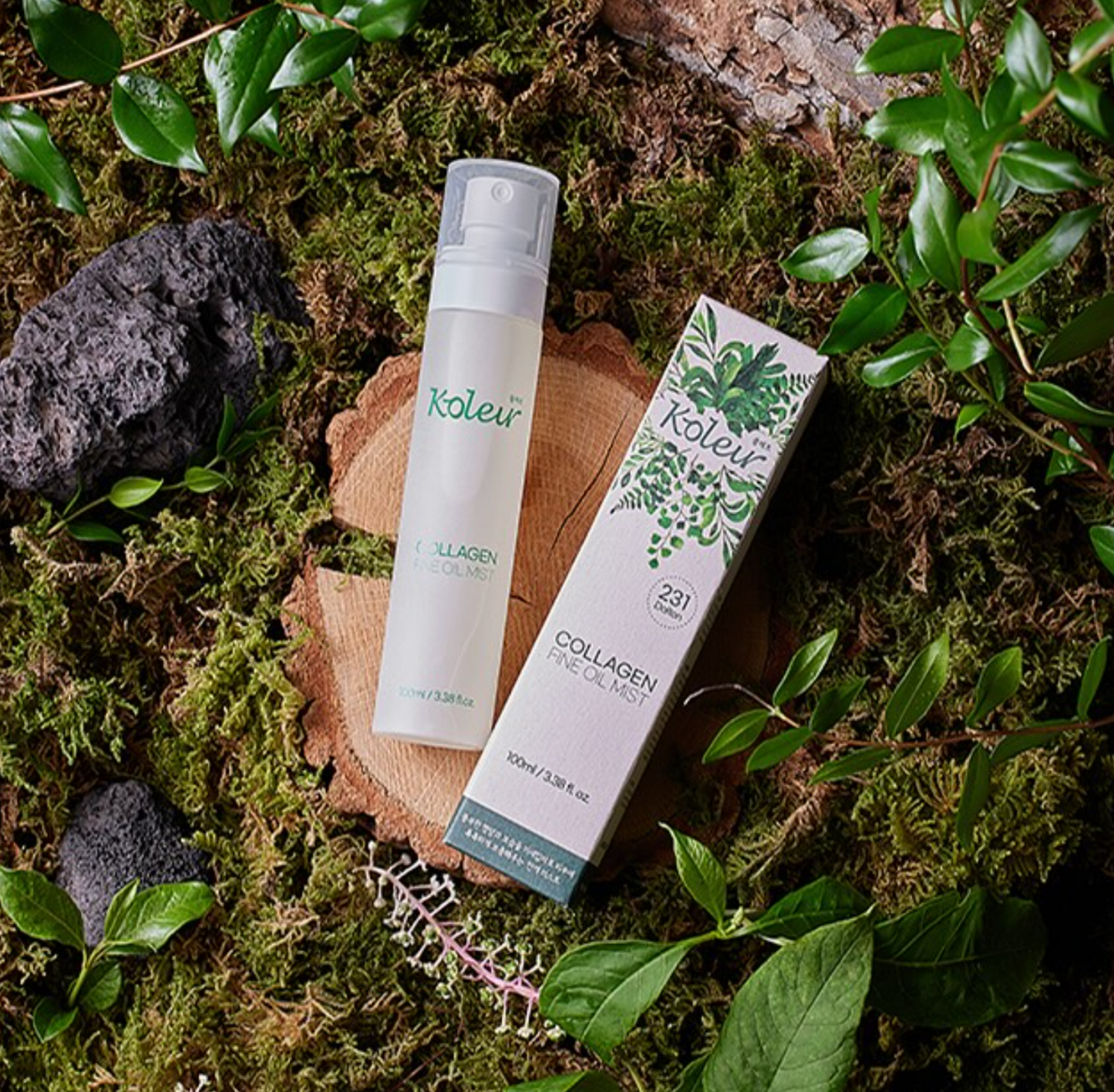 KOLEUR Collagen Fine Oil Mist packaging on a wooden stump surrounded by greenery and natural elements.