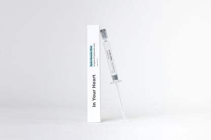 IN YOUR HEART Hydro Booster Shot in a clear syringe next to its packaging on a white background.