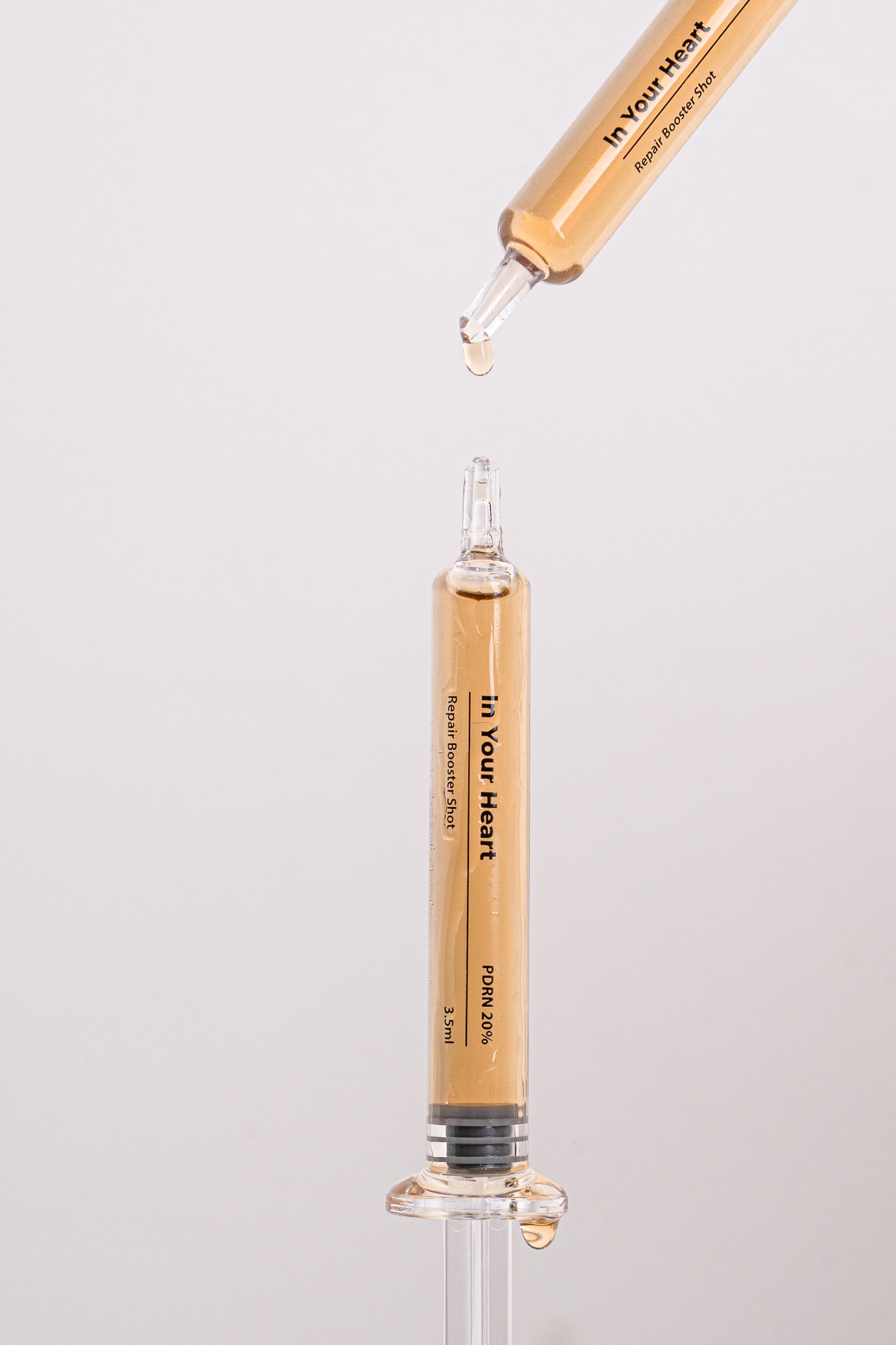 IN YOUR HEART Repair Booster Shot in a dropper and ampoule emphasizing skin rejuvenation.