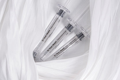 Three IN YOUR HEART Hydro Booster Shot ampoules nestled in soft white fabric.