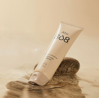 ATO 808 Cream tube resting on smooth stones surrounded by water, showcasing its soothing and hydrating properties.