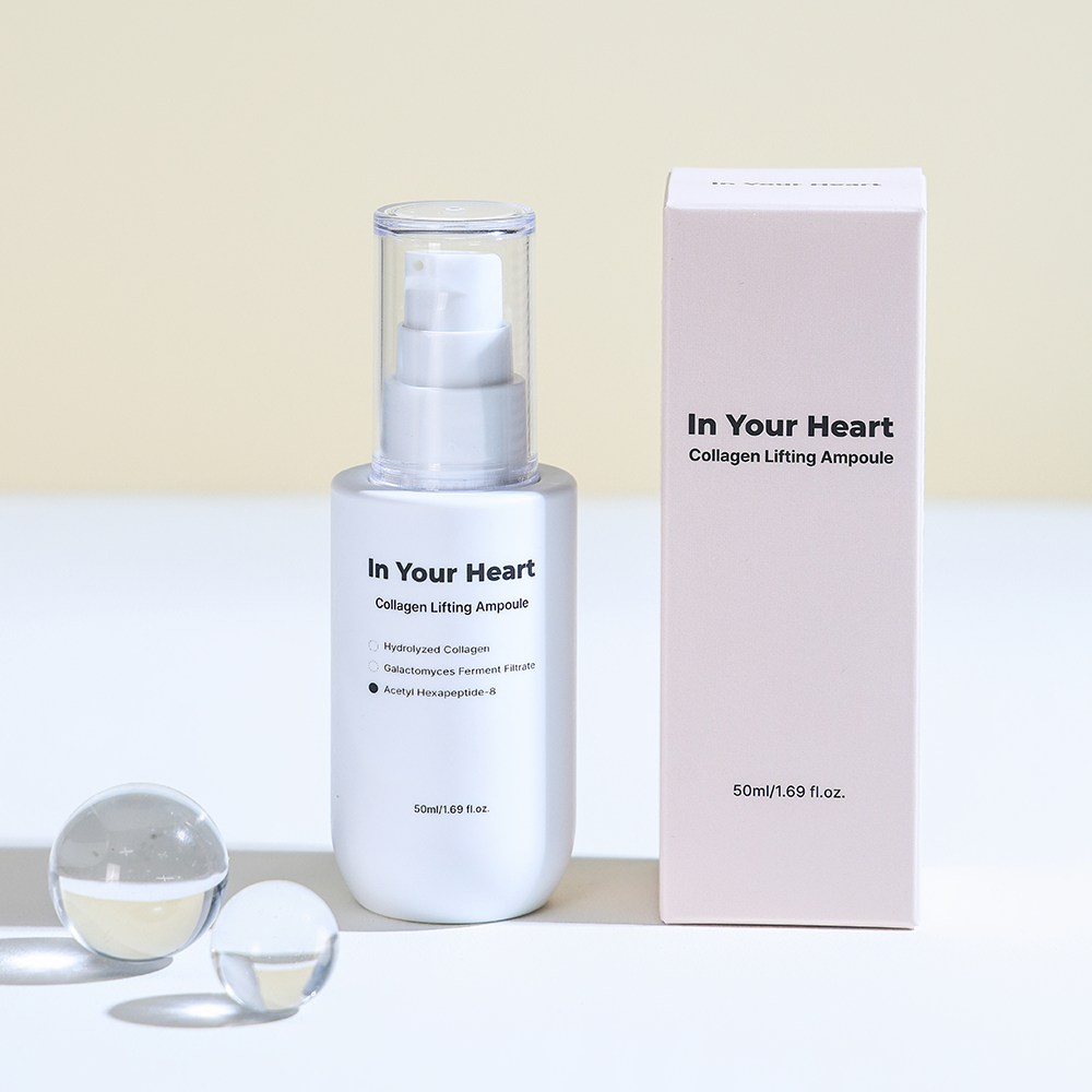 In Your Heart Collagen Lifting Ampoule bottle with box, styled with glass spheres for a clean look.