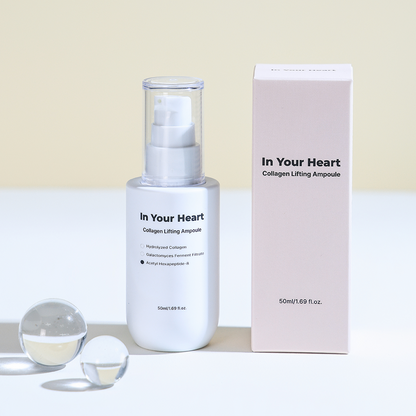 In Your Heart Collagen Lifting Ampoule bottle with box, styled with glass spheres for a clean look.