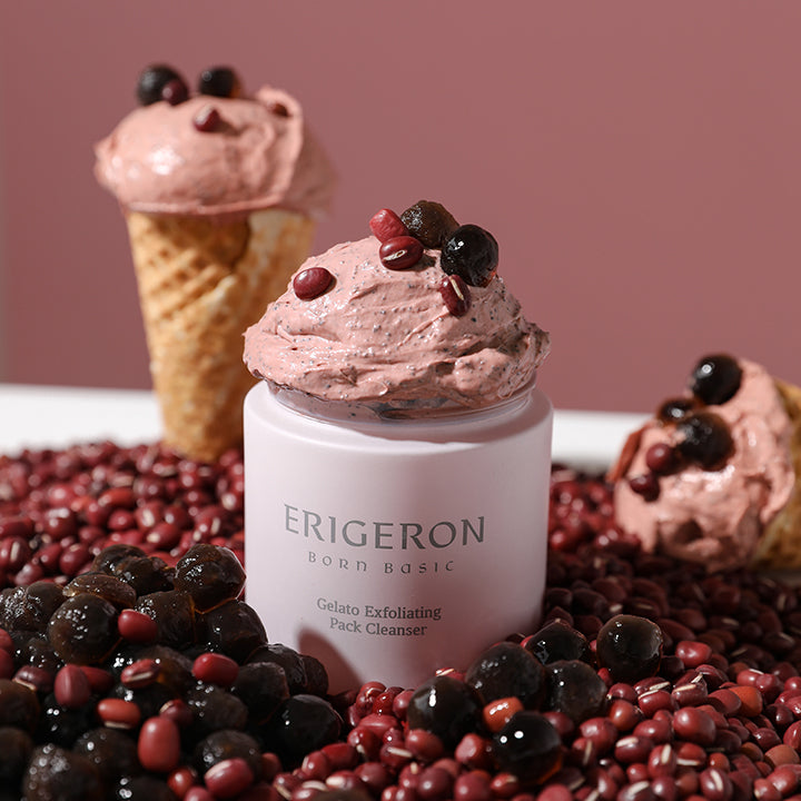 A jar of Erigeron Gelato Exfoliating Pack surrounded by raspberries, red beans, and an ice cream cone filled with pink cream, showcasing its creamy texture and natural ingredients.