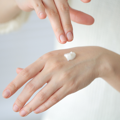 dollop of 'In Your Heart Calming Care Cream' being applied to the back of a hand, showing its gentle and hydrating texture.