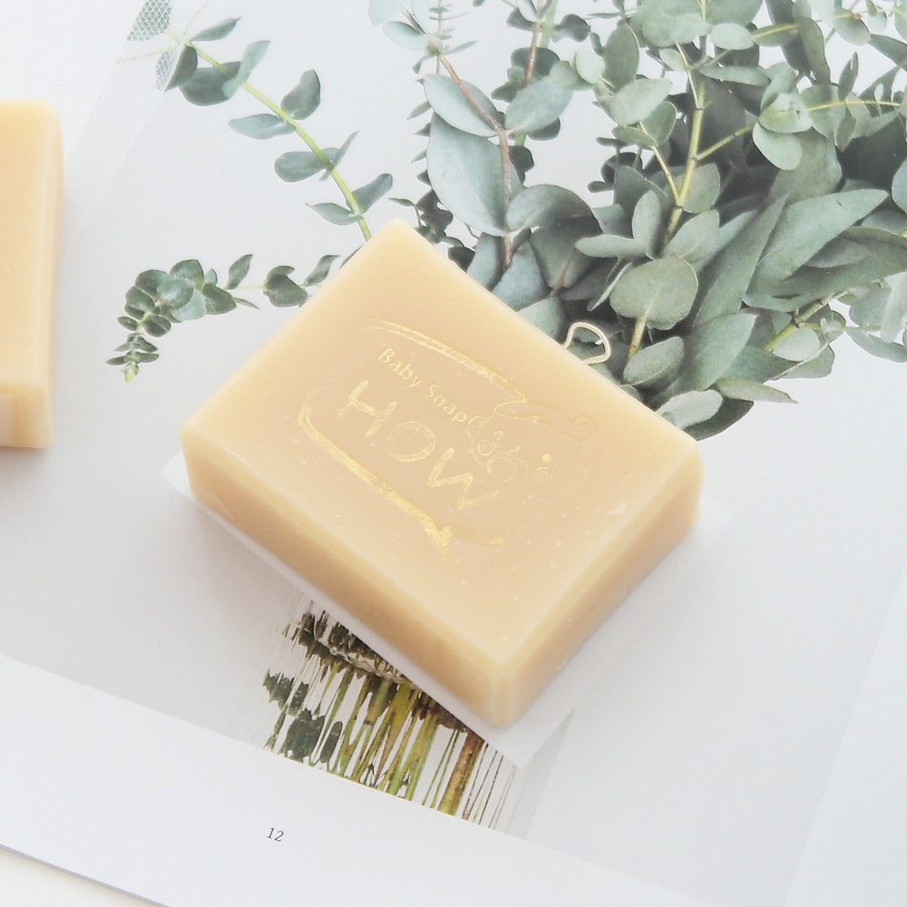 light yellow bar of soap with picture of eucalyptus leaves behind it