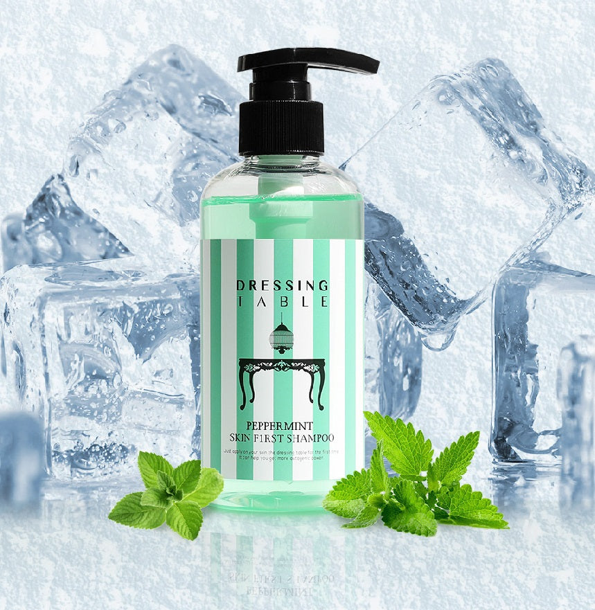 Green shampoo in plastic bottle with black pump next to mint leaves