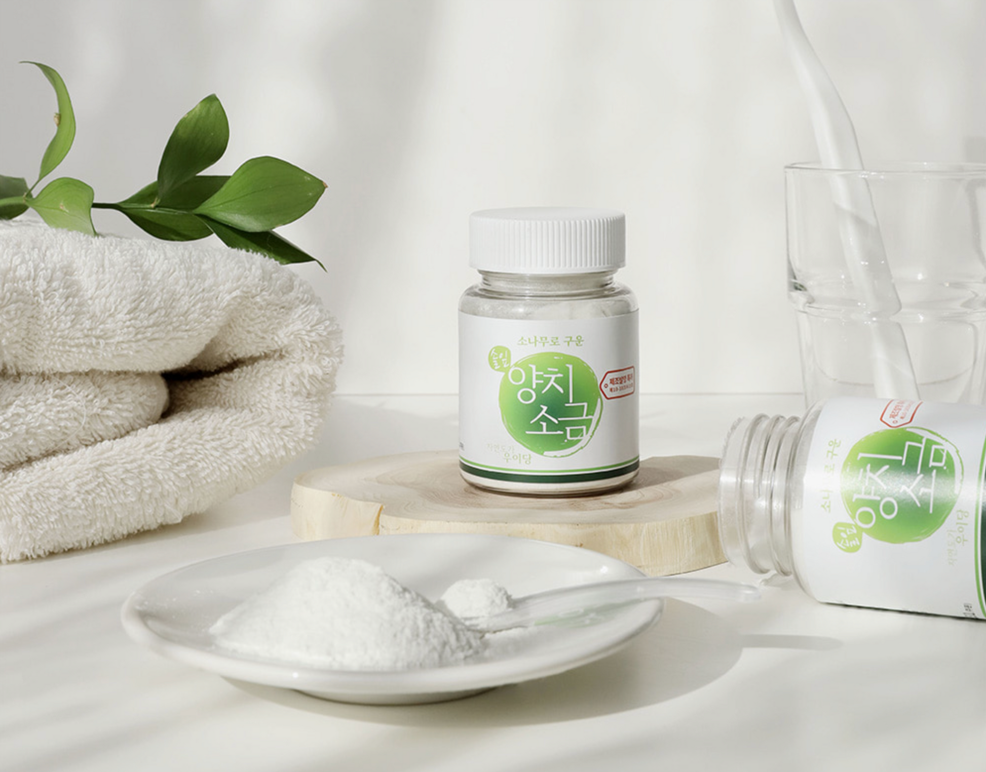 salt on white glass plate next to bottles and towel 