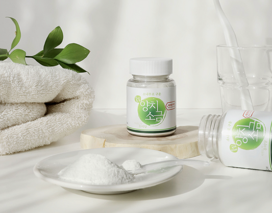 salt on white glass plate next to bottles and towel 