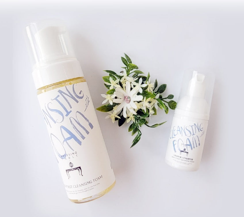 DressingTable Skin First Cleansing Foam in two sizes, displayed alongside fresh white jasmine flowers for a natural aesthetic