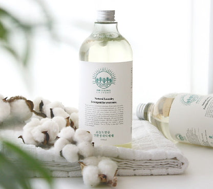bottle of clear detergent on towel next to cotton plant
