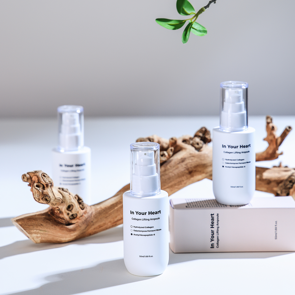 Three bottles of In Your Heart Collagen Lifting Ampoule styled with natural wood and green leaves.