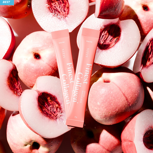 Two VITIV Finest Collagen peach-flavored sticks placed among fresh, halved peaches with vibrant, juicy textures.