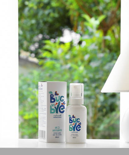 A bright image showcasing the [DressingTable] Bug Vi Bye Spray against a lush, green outdoor background, emphasizing its natural and eco-friendly formulation. The spray bottle stands upright next to its packaging, with greenery softly blurred in the backdrop.