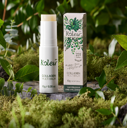 Koleur Collagen Multibalm displayed with its packaging on a mossy surface surrounded by greenery, highlighting its natural-inspired design and portability.