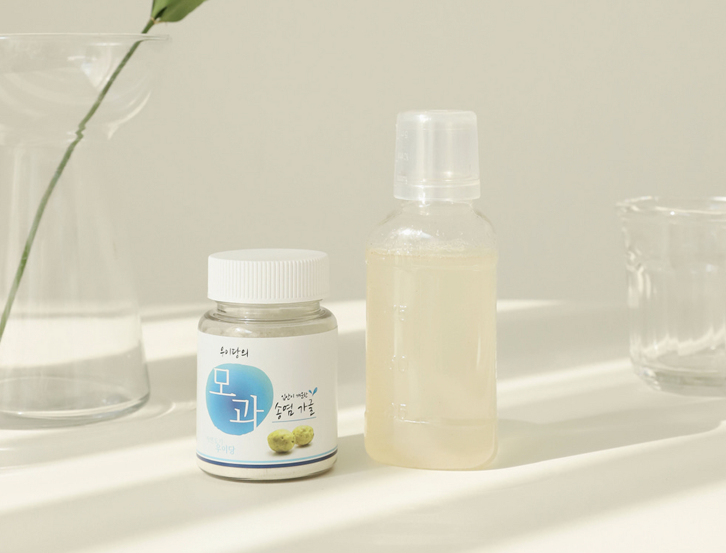 bottle with white cap next to plastic bottle filled with light yellow liquid
