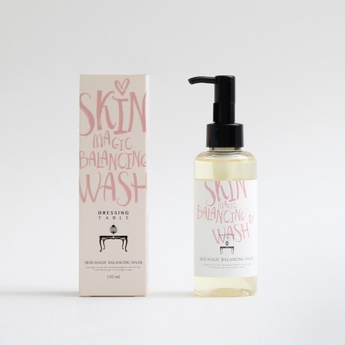 The Skin Magic Balancing Wash bottle next to its matching box, both featuring a minimalistic design with soft pink lettering, emphasizing elegance and purity.