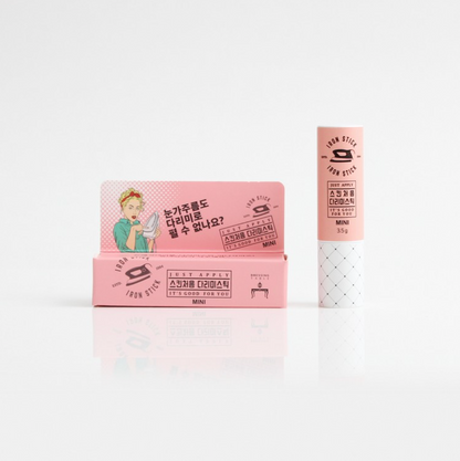 A mini version of the Iron Stick standing next to its packaging, with a playful illustration on a pink box highlighting its compact size and convenience.