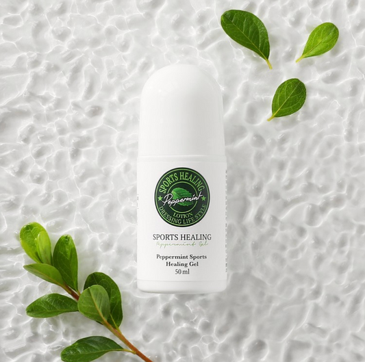 DressingTable Sports Healing Gel in a sleek white roll-on bottle, placed on a textured white background with green leaves for a natural touch.